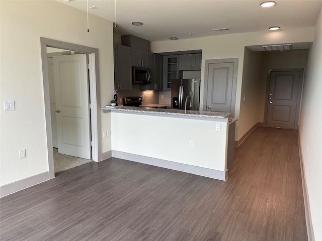 6955 Turtlewood Dr Unit 502, Houston, TX 77072 - kitchen with stainless steel appliances, a peninsula, dark wood-style flooring, baseboards, and recessed lighting