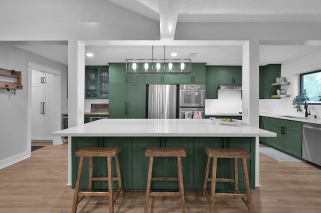 914 Rustic Oaks Dr, Magnolia, TX 77354 - kitchen with green cabinets, appliances with stainless steel finishes, open shelves, light wood-type flooring, and light countertops