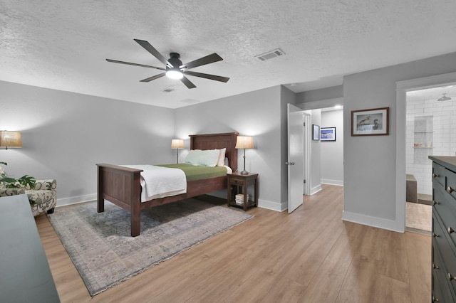 914 Rustic Oaks Dr, Magnolia, TX 77354 - bedroom with light wood finished floors, a textured ceiling, baseboards, and a ceiling fan
