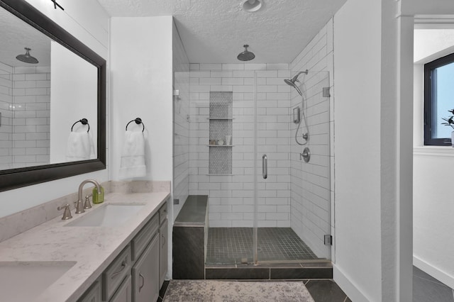 914 Rustic Oaks Dr, Magnolia, TX 77354 - bathroom featuring a shower stall, a textured ceiling, and double vanity
