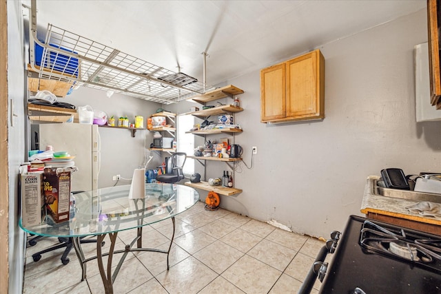 2106 Antoine Dr, Houston, TX 77055 - kitchen with light tile patterned floors, black gas stove, light brown cabinetry, and open shelves