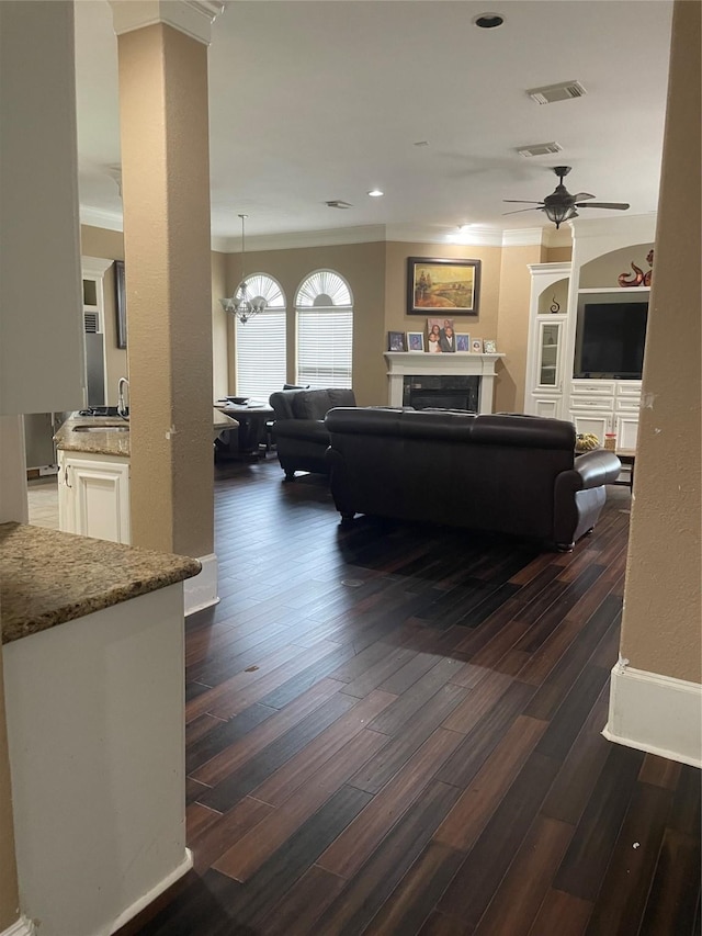 8930 Water Crest Trl, Richmond, TX 77469 - living area with crown molding, a fireplace, ceiling fan, dark wood-type flooring, and recessed lighting