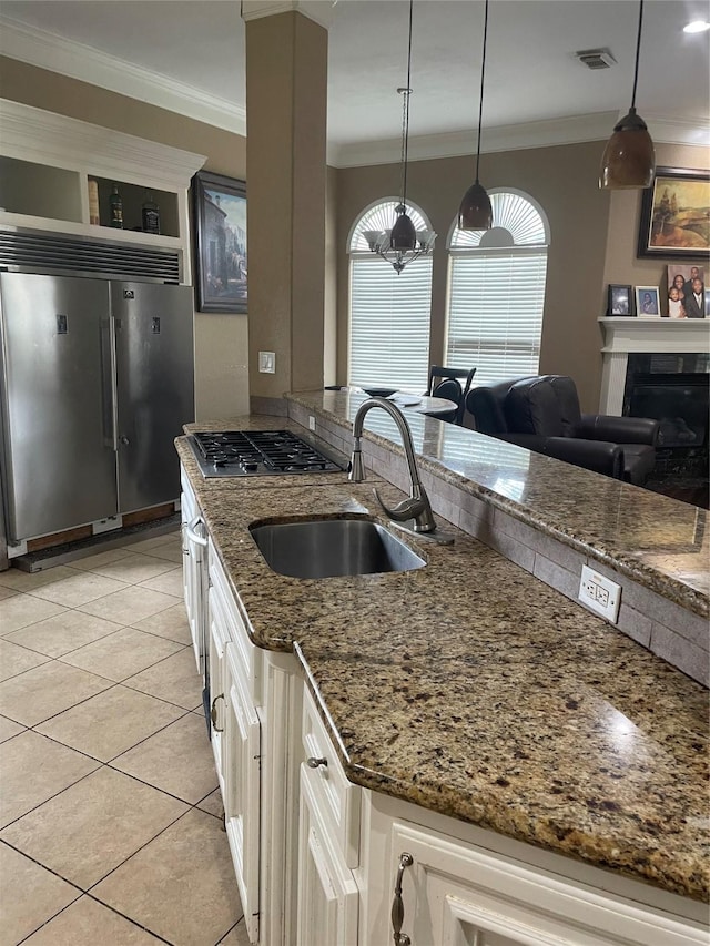 8930 Water Crest Trl, Richmond, TX 77469 - kitchen with stainless steel appliances, a sink, ornamental molding, light tile patterned floors, and dark stone counters