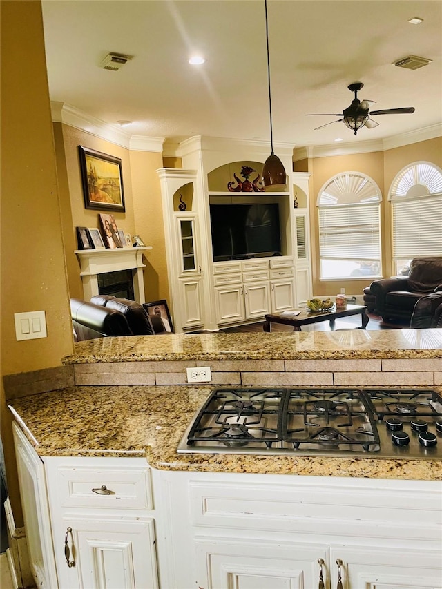 8930 Water Crest Trl, Richmond, TX 77469 - kitchen featuring stainless steel gas cooktop, ceiling fan, open floor plan, ornamental molding, and decorative light fixtures