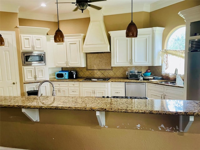 8930 Water Crest Trl, Richmond, TX 77469 - kitchen featuring stainless steel microwave, a sink, a ceiling fan, ornamental molding, and light stone counters