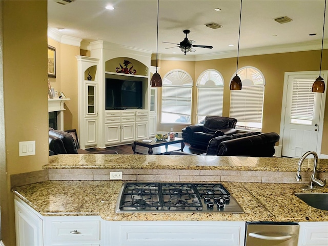 8930 Water Crest Trl, Richmond, TX 77469 - kitchen with stainless steel gas cooktop, a ceiling fan, ornamental molding, a sink, and white cabinets