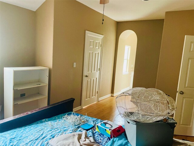 8930 Water Crest Trl, Richmond, TX 77469 - bedroom featuring wood finished floors, arched walkways, and baseboards