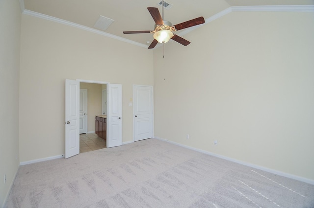 unfurnished bedroom with light carpet, baseboards, high vaulted ceiling, connected bathroom, and ornamental molding