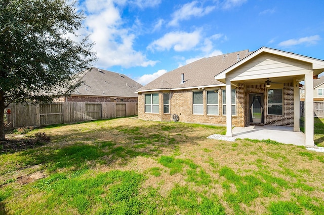 rear view of property featuring ceiling fan, a patio area, and brick siding