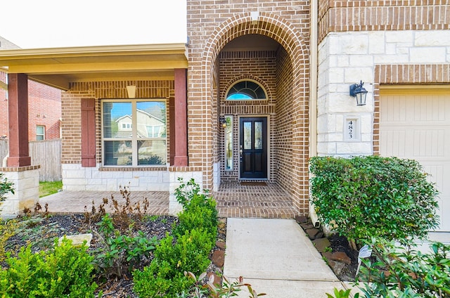 entrance to property featuring brick siding and covered porch