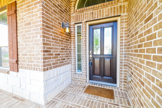 view of exterior entry with brick siding