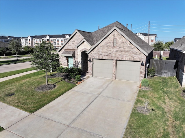 french provincial home featuring concrete driveway, brick siding, a garage, and roof with shingles