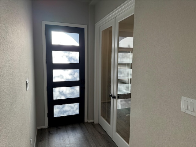 entryway featuring french doors, dark wood-style floors, and a textured wall