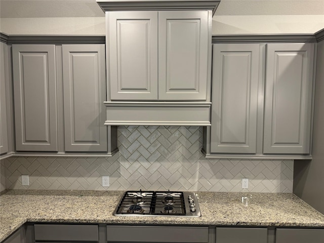 kitchen featuring stainless steel gas cooktop, gray cabinets, and tasteful backsplash