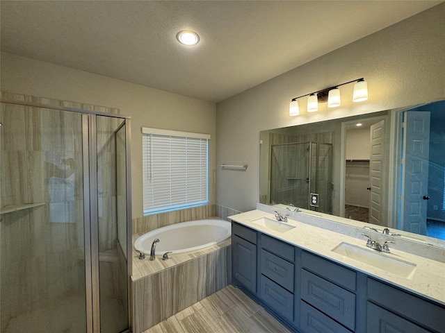 bathroom with a shower stall, a garden tub, double vanity, and a walk in closet
