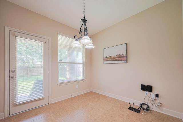unfurnished room featuring plenty of natural light, baseboards, and light tile patterned flooring