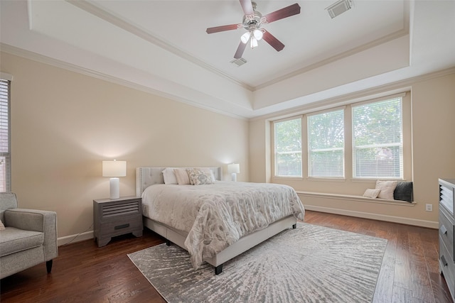 bedroom featuring a raised ceiling, crown molding, baseboards, dark wood finished floors, and ceiling fan