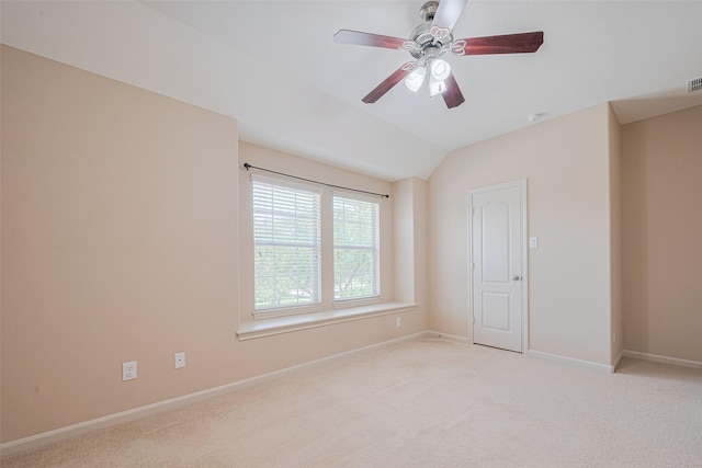 unfurnished room featuring light carpet, baseboards, vaulted ceiling, and ceiling fan