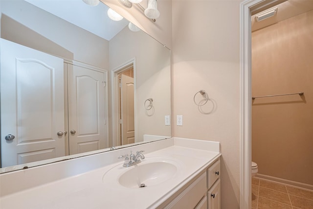 bathroom featuring toilet, vanity, and tile patterned flooring