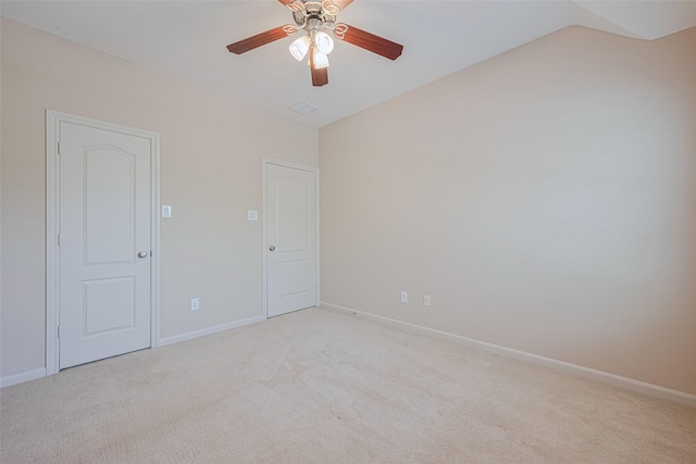 unfurnished room featuring light colored carpet, a ceiling fan, baseboards, and vaulted ceiling