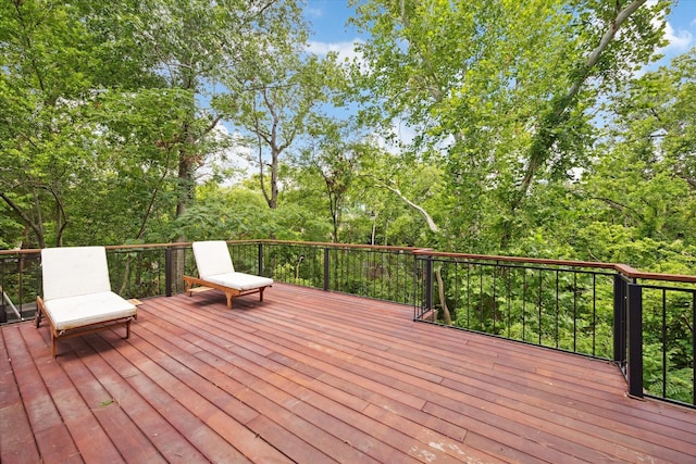 wooden deck with view of wooded area