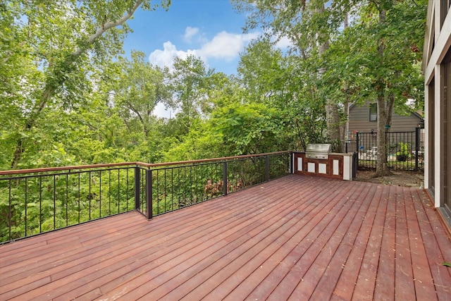 wooden terrace with an outdoor kitchen and area for grilling