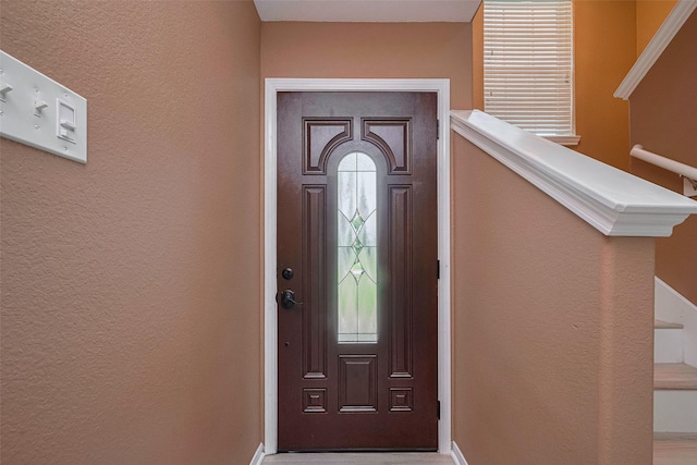 entrance foyer with a textured wall and baseboards