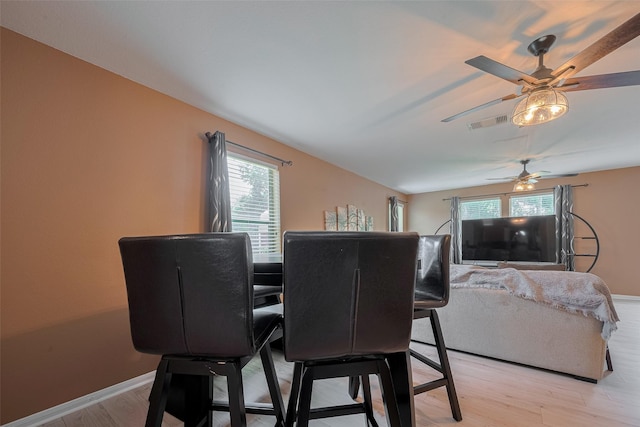 dining space featuring a ceiling fan, light wood-type flooring, and baseboards