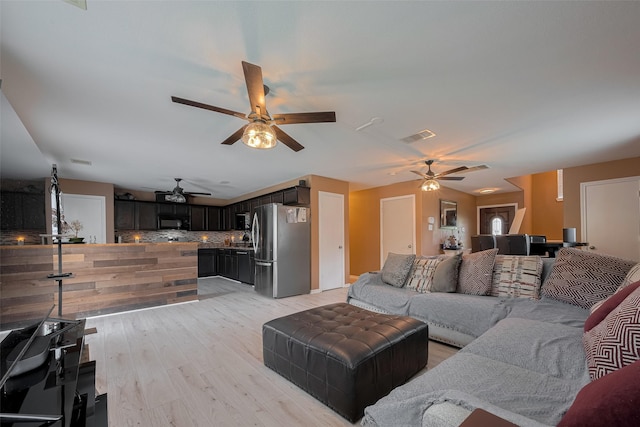 living room with a ceiling fan and light wood-type flooring