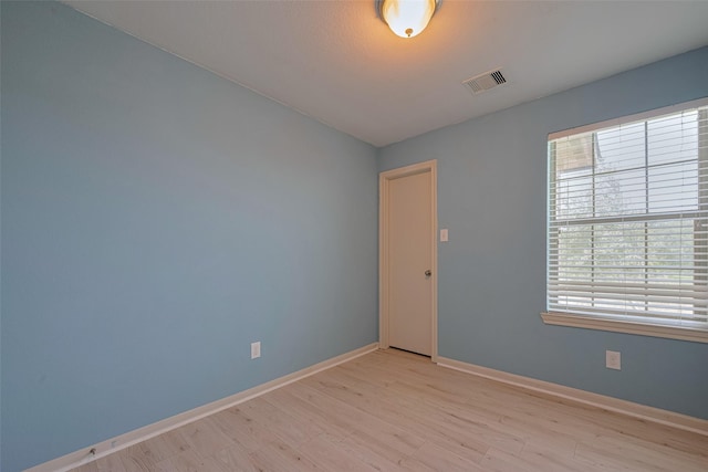 unfurnished room with healthy amount of natural light, light wood-style flooring, and baseboards