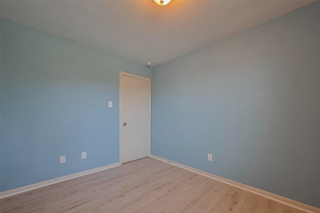 spare room with light wood finished floors and baseboards
