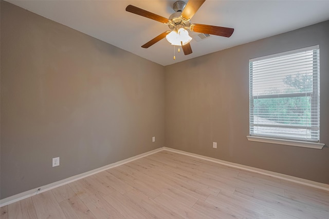 spare room with baseboards, a ceiling fan, and light wood-style floors