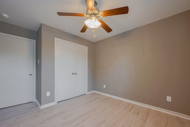 unfurnished bedroom featuring light wood finished floors, baseboards, and a ceiling fan