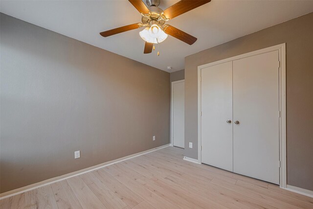 unfurnished bedroom with light wood-style floors, baseboards, a closet, and a ceiling fan