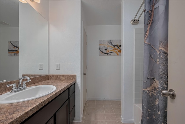 bathroom featuring tile patterned flooring, vanity, shower / bath combo with shower curtain, and baseboards