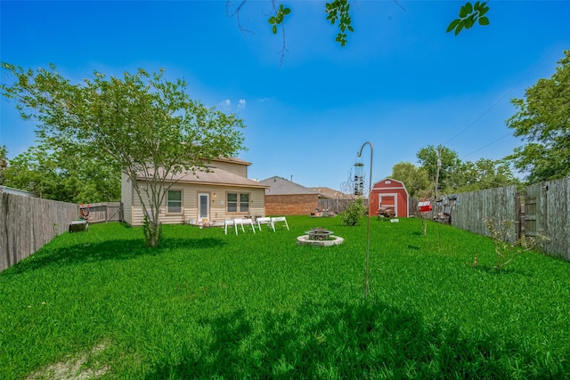 view of yard featuring a shed, a fire pit, and an outdoor structure