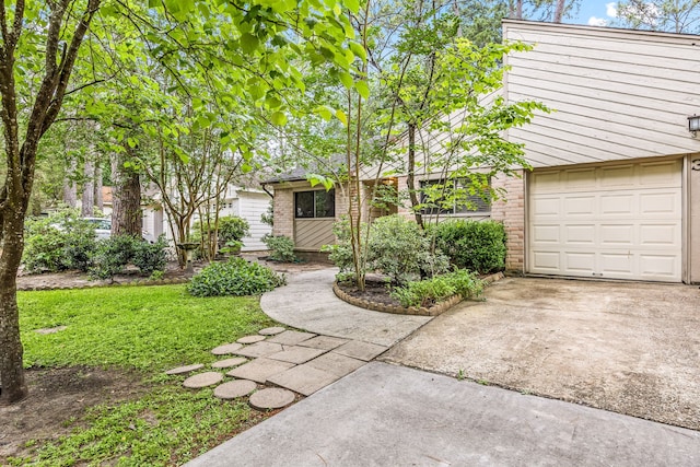 view of front of home featuring brick siding, an attached garage, and concrete driveway