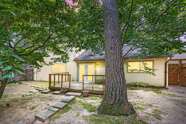 back of house with a wooden deck, a gate, and fence
