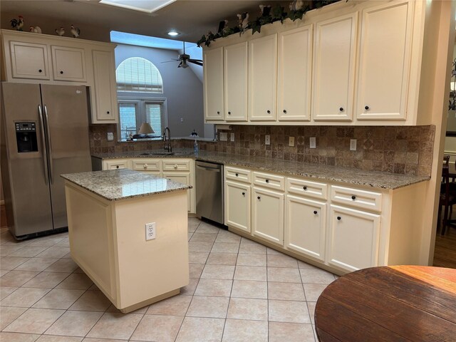 3923 Fordham Park Ct, Pasadena, TX 77058 - kitchen featuring stainless steel appliances, a sink, ceiling fan, light tile patterned flooring, and backsplash