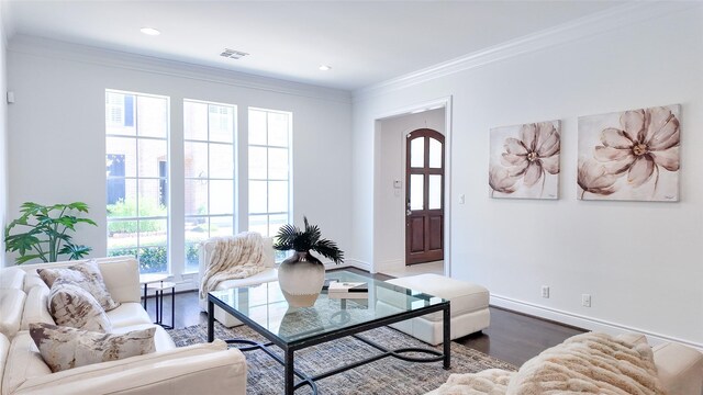 living room with wood finished floors, ornamental molding, baseboards, and recessed lighting
