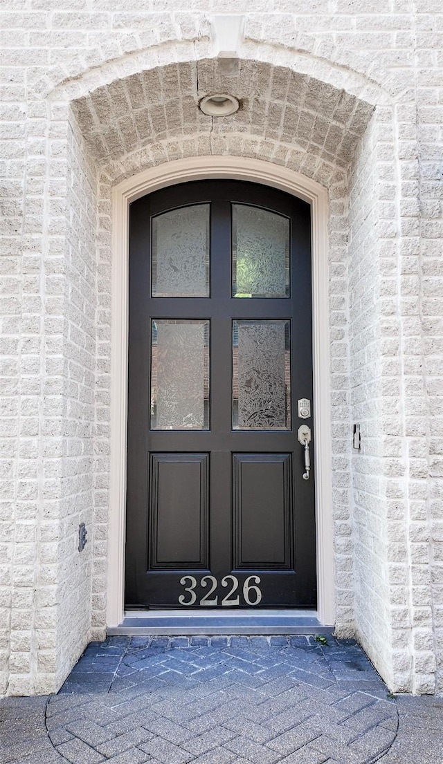 view of exterior entry featuring brick siding