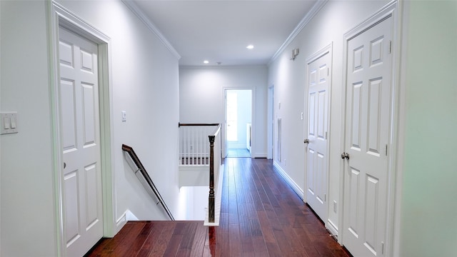hallway with an upstairs landing, ornamental molding, dark wood finished floors, recessed lighting, and baseboards