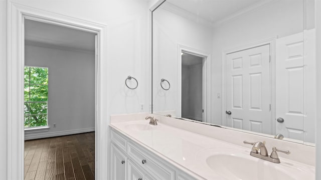 bathroom featuring crown molding, wood finished floors, and double vanity
