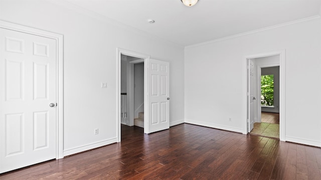 unfurnished bedroom featuring dark wood finished floors, ornamental molding, and baseboards