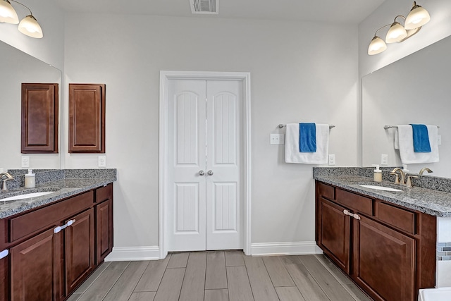 8207 Oxbow Manor Ln, Cypress, TX 77433 - full bath with baseboards, two vanities, and wood finish floors