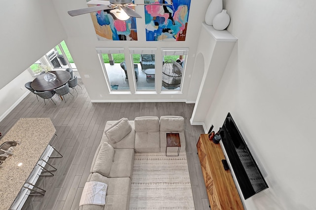 8207 Oxbow Manor Ln, Cypress, TX 77433 - living area with a towering ceiling, wood finished floors, baseboards, and a ceiling fan