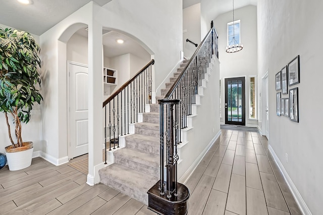 8207 Oxbow Manor Ln, Cypress, TX 77433 - foyer featuring healthy amount of natural light, wood tiled floors, stairway, baseboards, and a high ceiling