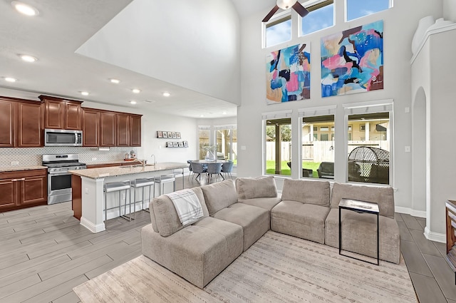 8207 Oxbow Manor Ln, Cypress, TX 77433 - living room featuring recessed lighting, a high ceiling, wood tiled floors, ceiling fan, and baseboards