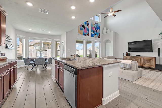 8207 Oxbow Manor Ln, Cypress, TX 77433 - kitchen with stainless steel dishwasher, open floor plan, wood finish floors, a sink, and healthy amount of natural light