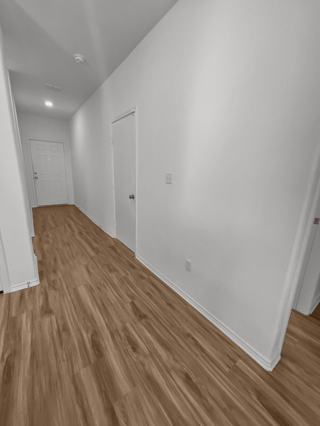 spare room featuring wood finished floors, baseboards, and a smoke detector